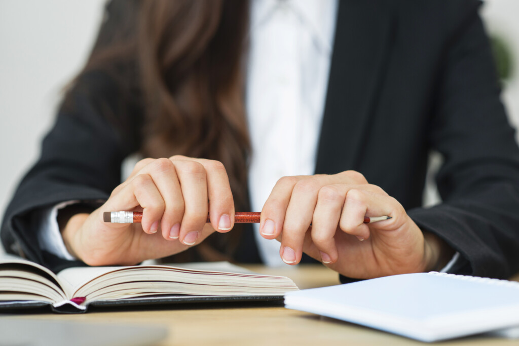 close-up-businesswoman-holding-red-pencil-her-two-hands-desk