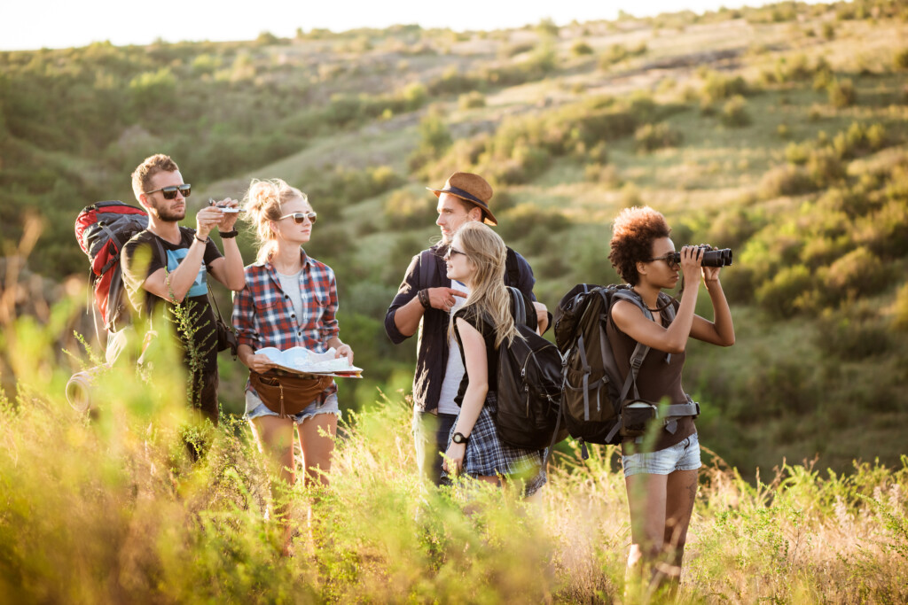 young-friends-with-backpacks-enjoying-view-traveling-canyon