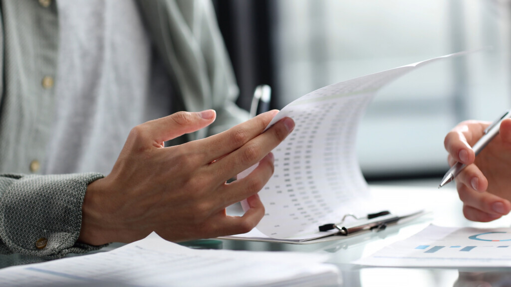 person-is-looking-piece-paper-with-pen-their-hand