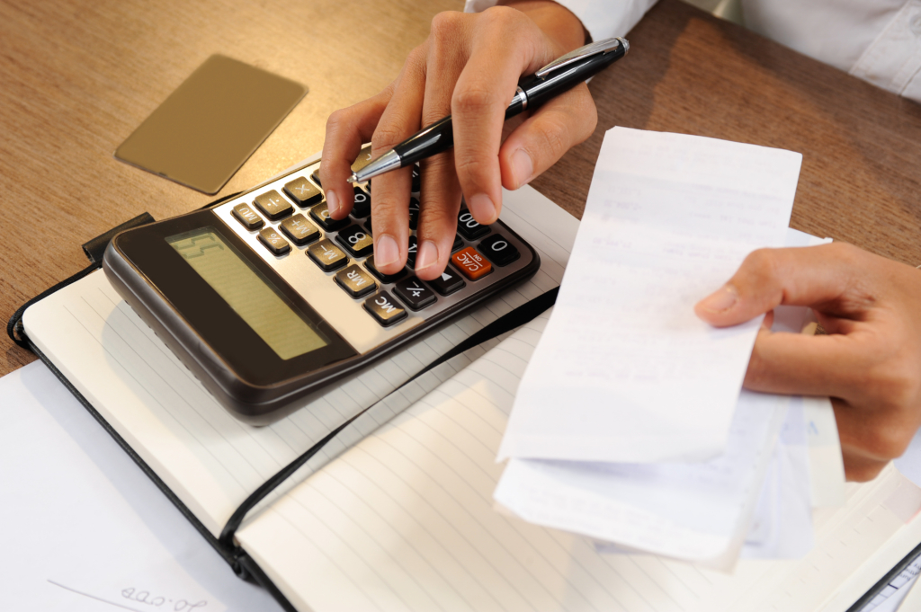 closeup-person-holding-bills-calculating-them